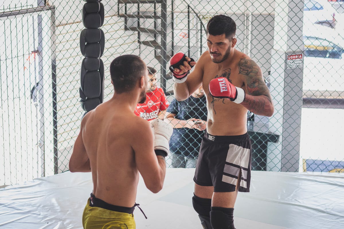 Two fighters sparring in MMA cage
