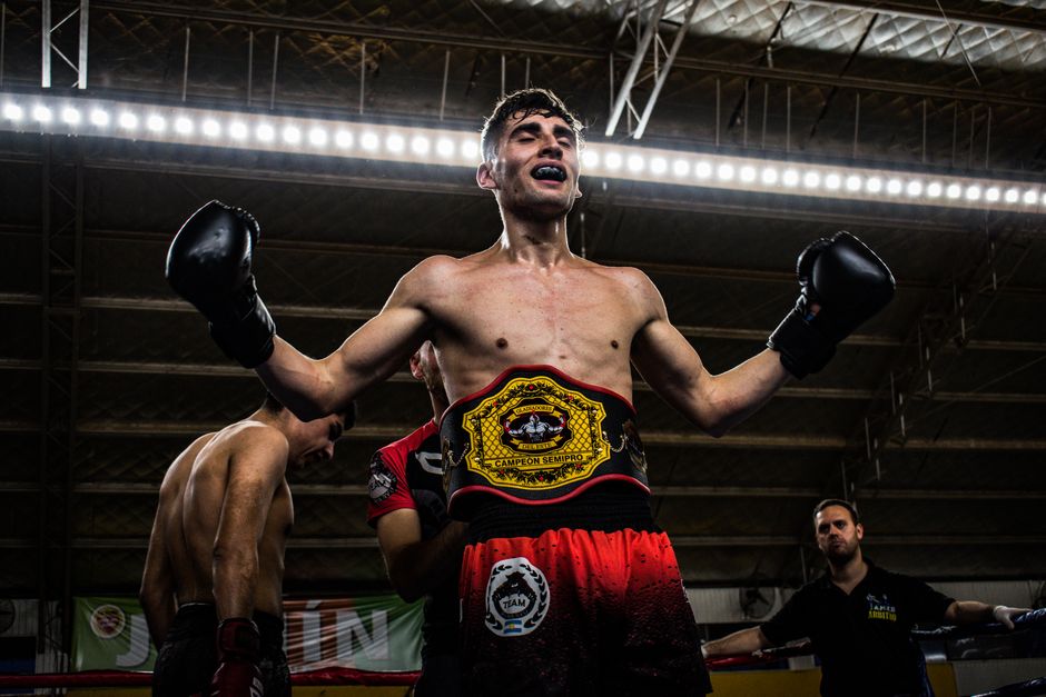 Victorious boxer celebrates in the ring wearing championship belt