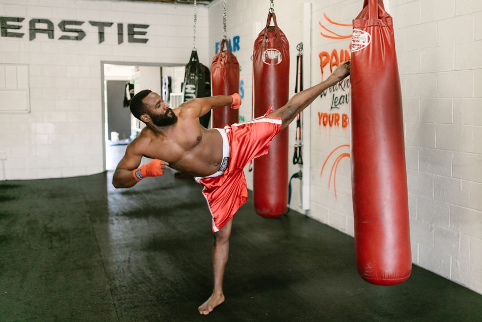 Fighter training high kicks on a heavy bag