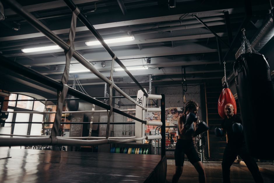 Boxing gym training session with ring and heavy bags