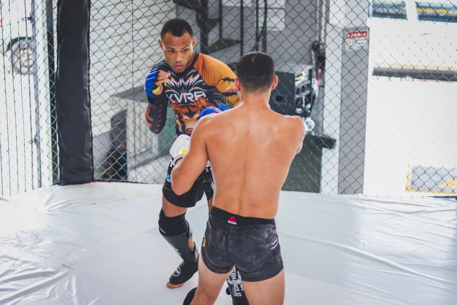 Two MMA fighters squaring off inside the cage during a striking exchange