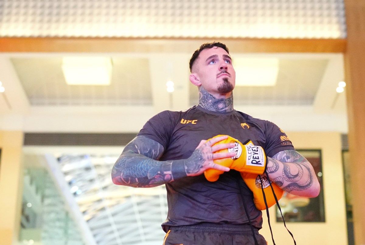 Tom Aspinall at UFC open workout holding Cleto Reyes boxing gloves, illustrating his training approach