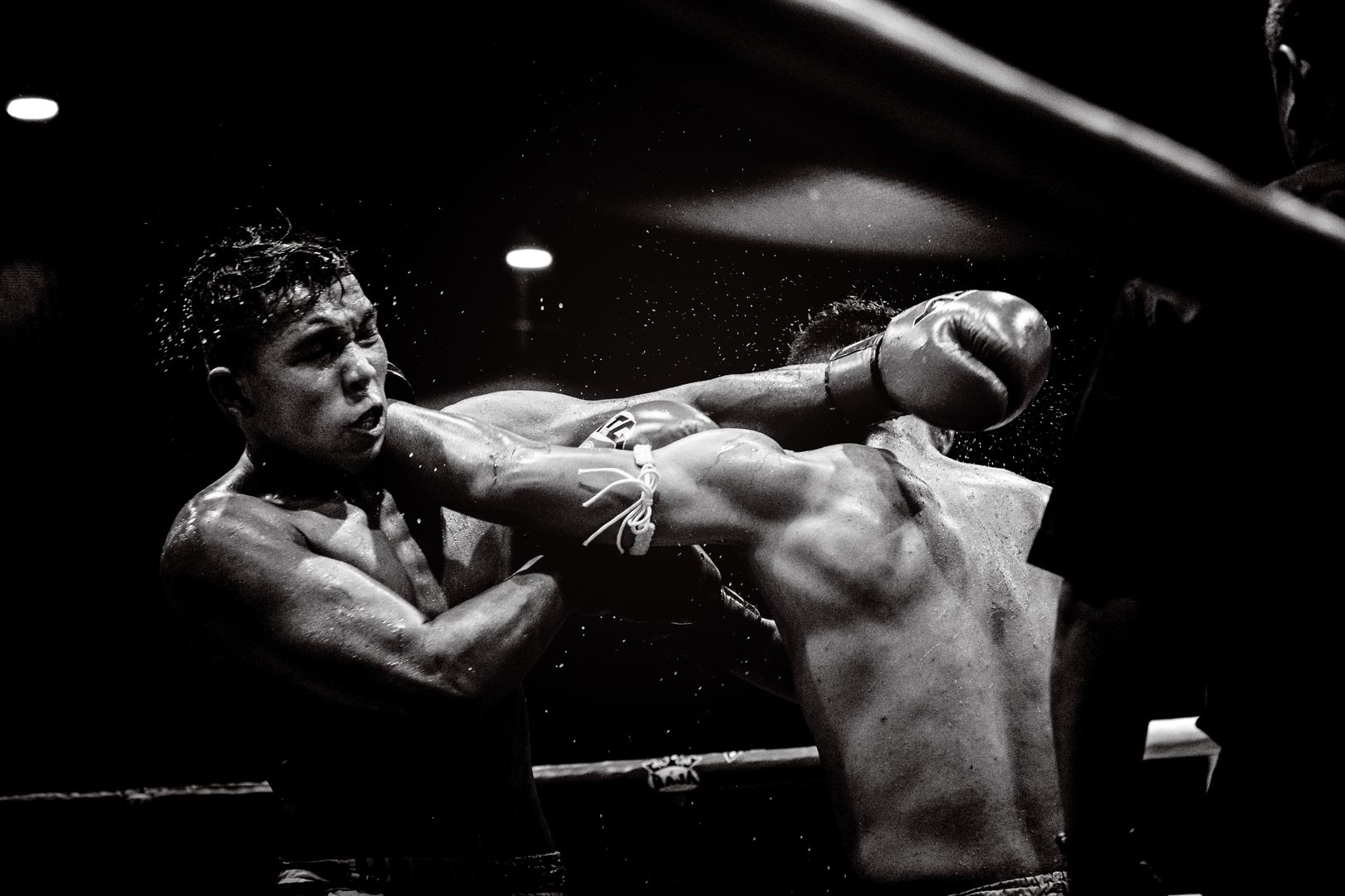 Powerful black and white photo of a moment of impact in a boxing match.