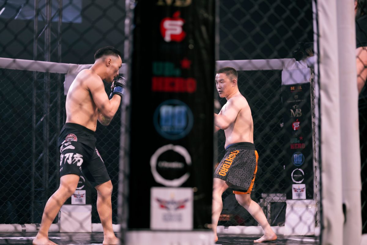Two MMA fighters squaring off in the center of the cage