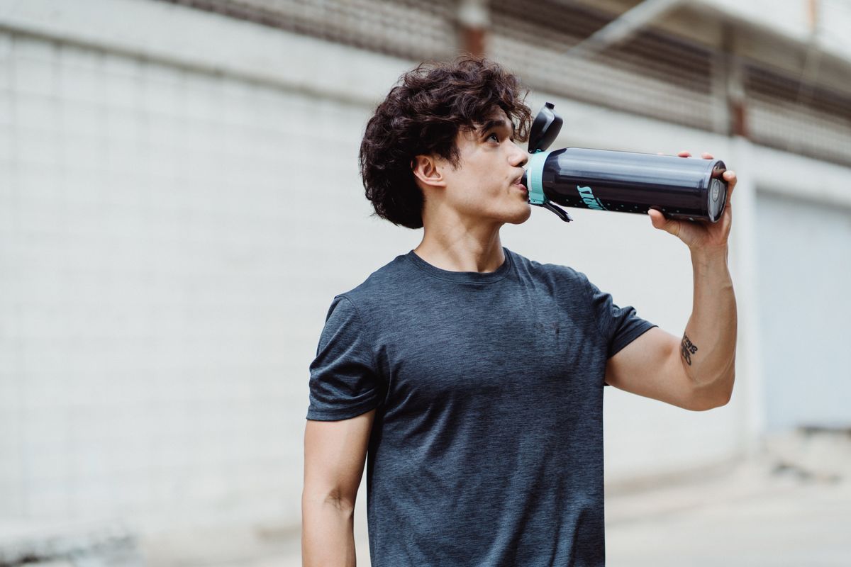 Athlete rehydrating from a water bottle after a workout