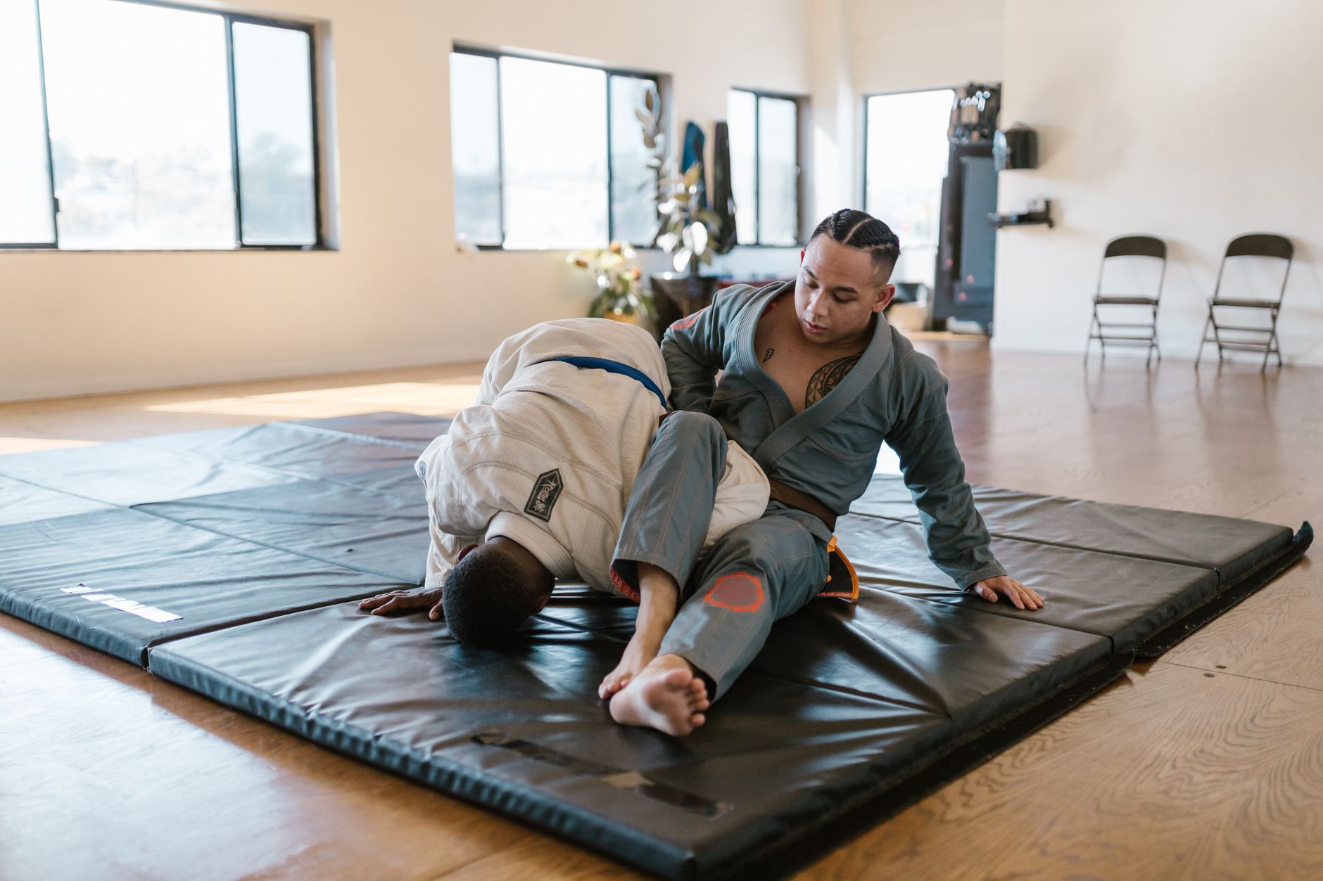 Grapplers drilling submission control on the training mats