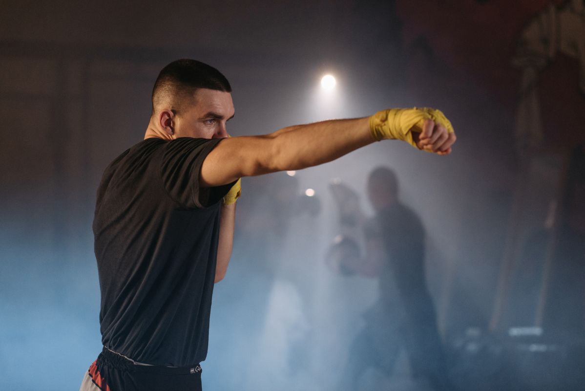 Fighter throwing a straight punch with hand wraps in a smoky gym