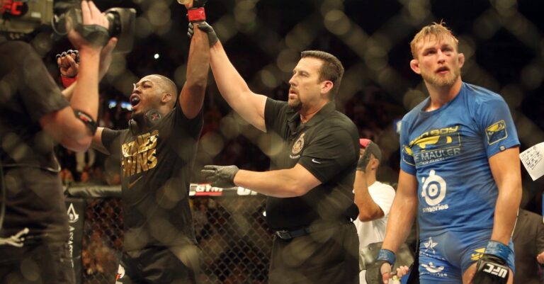 Jon Jones has his hand raised after a controversial split scoring at UFC 165 as Alexander Gustafsson looks on