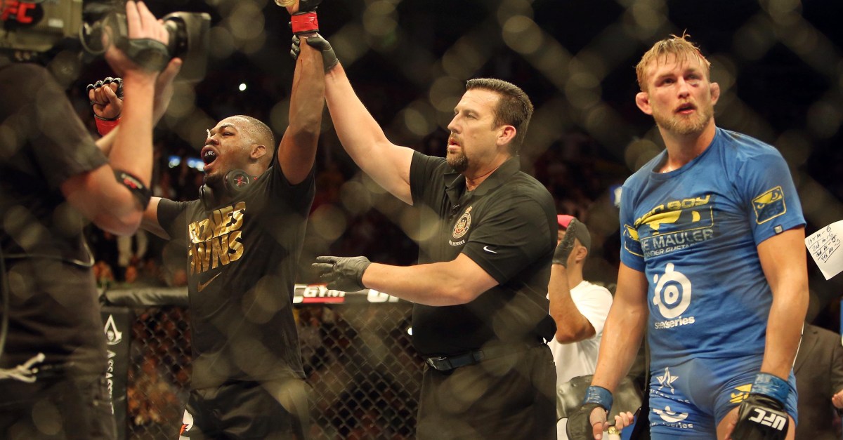 Jon Jones has his hand raised after a controversial split scoring at UFC 165 as Alexander Gustafsson looks on