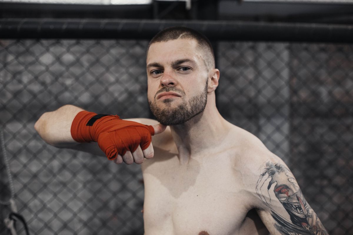 MMA fighter in octagon cage with hand wraps