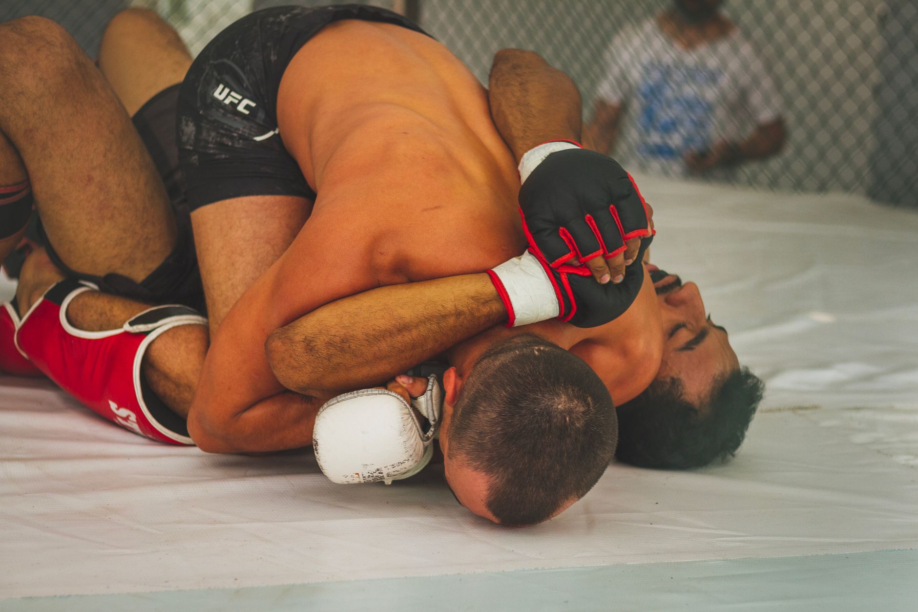 MMA grappling on mat showing submission control — Aspinall BJJ game