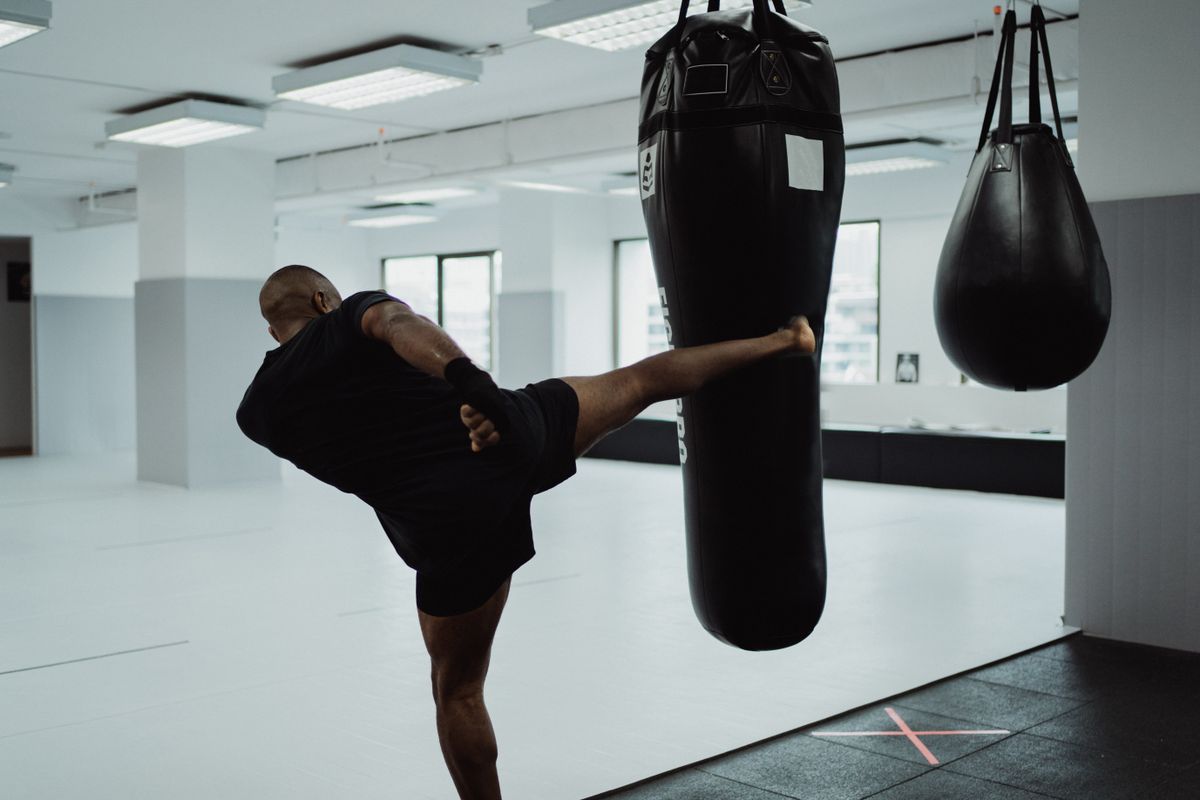 Fighter drilling a high kick, karate-based striking