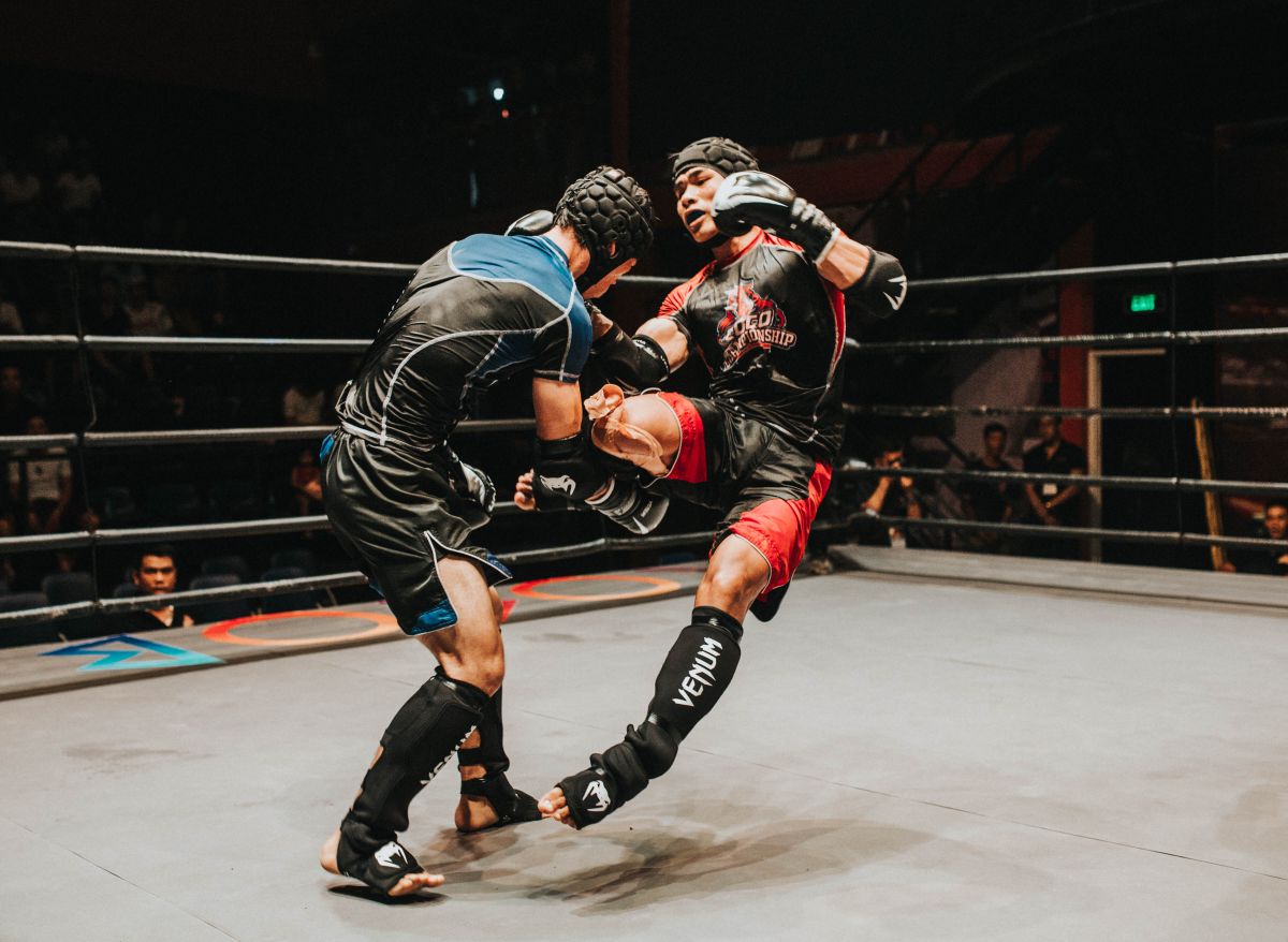 MMA fighter throwing a knee strike inside the ring