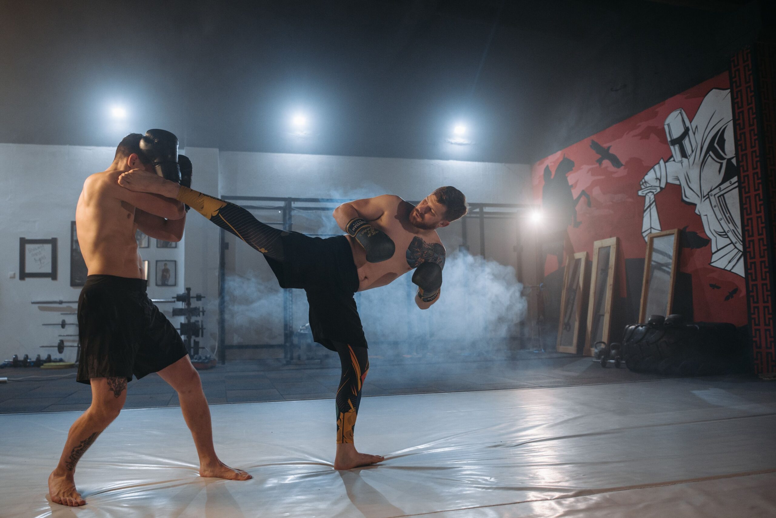 Fighter landing a high kick during a training session in a gym