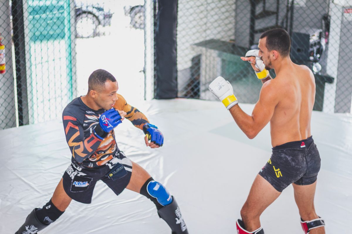 Two MMA fighters sparring in a cage