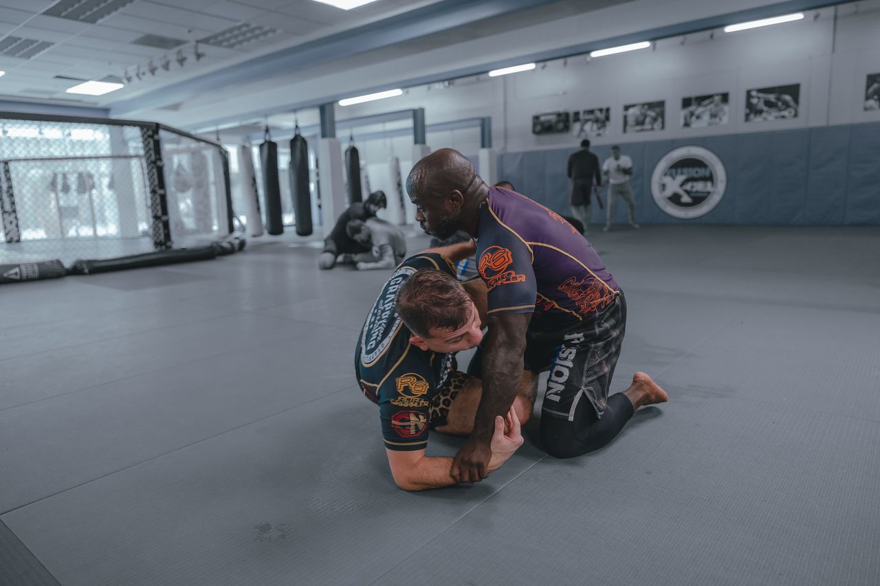 MMA athlete in grappling training — wrestling defense and ground control technique