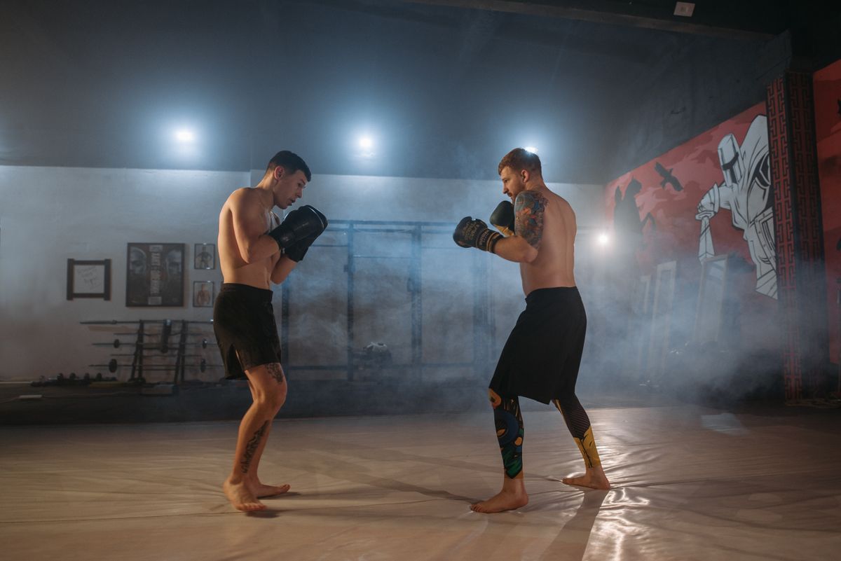 MMA fighters sparring in gym — defensive pressure work