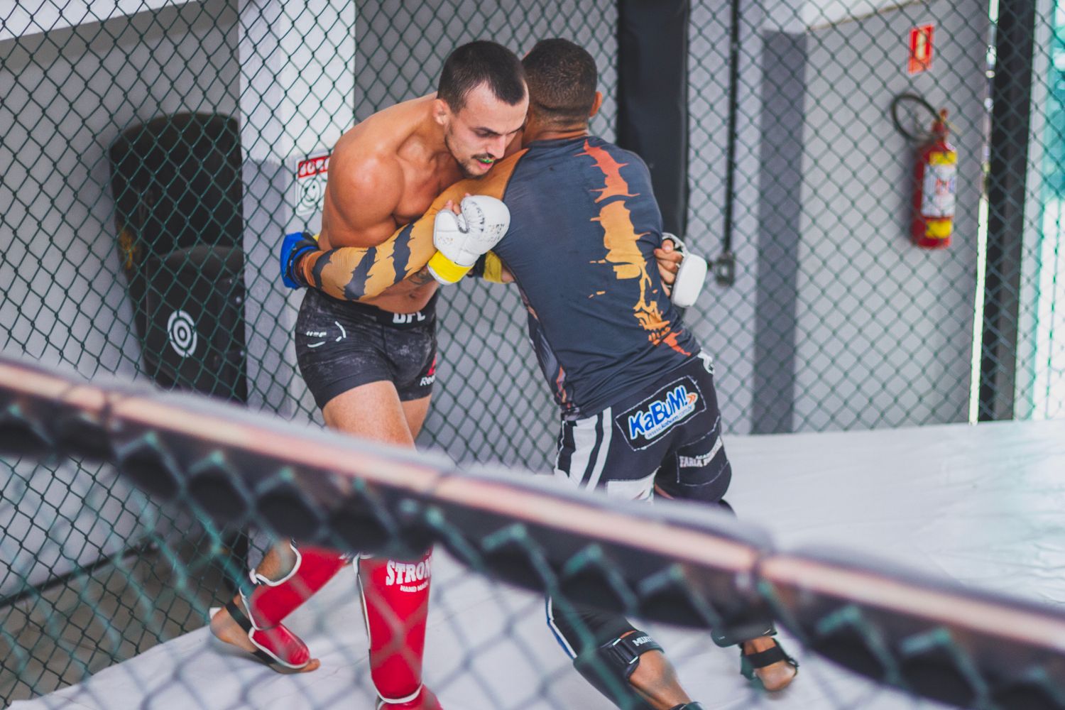 Fighter defending against the cage fence in MMA