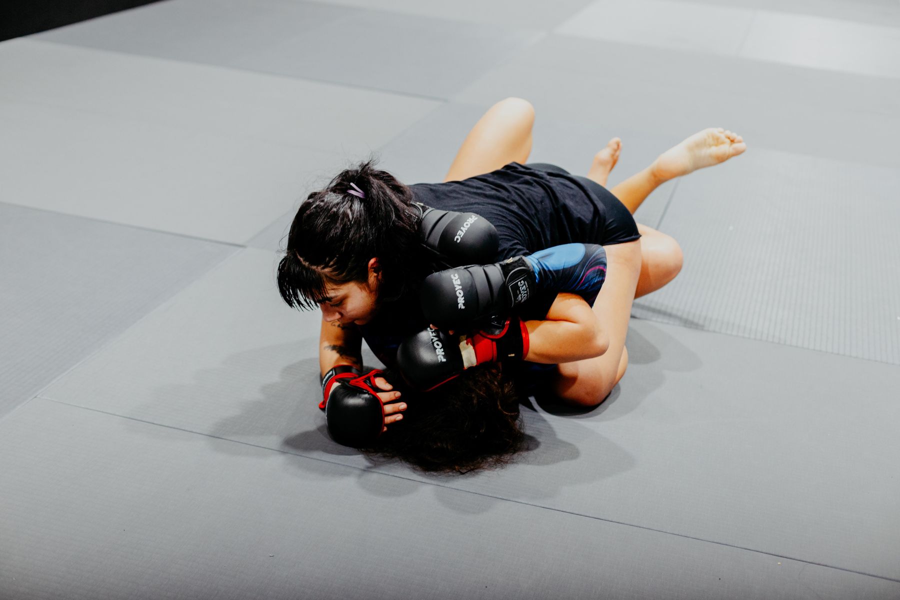 Female mixed martial artist grappling during training