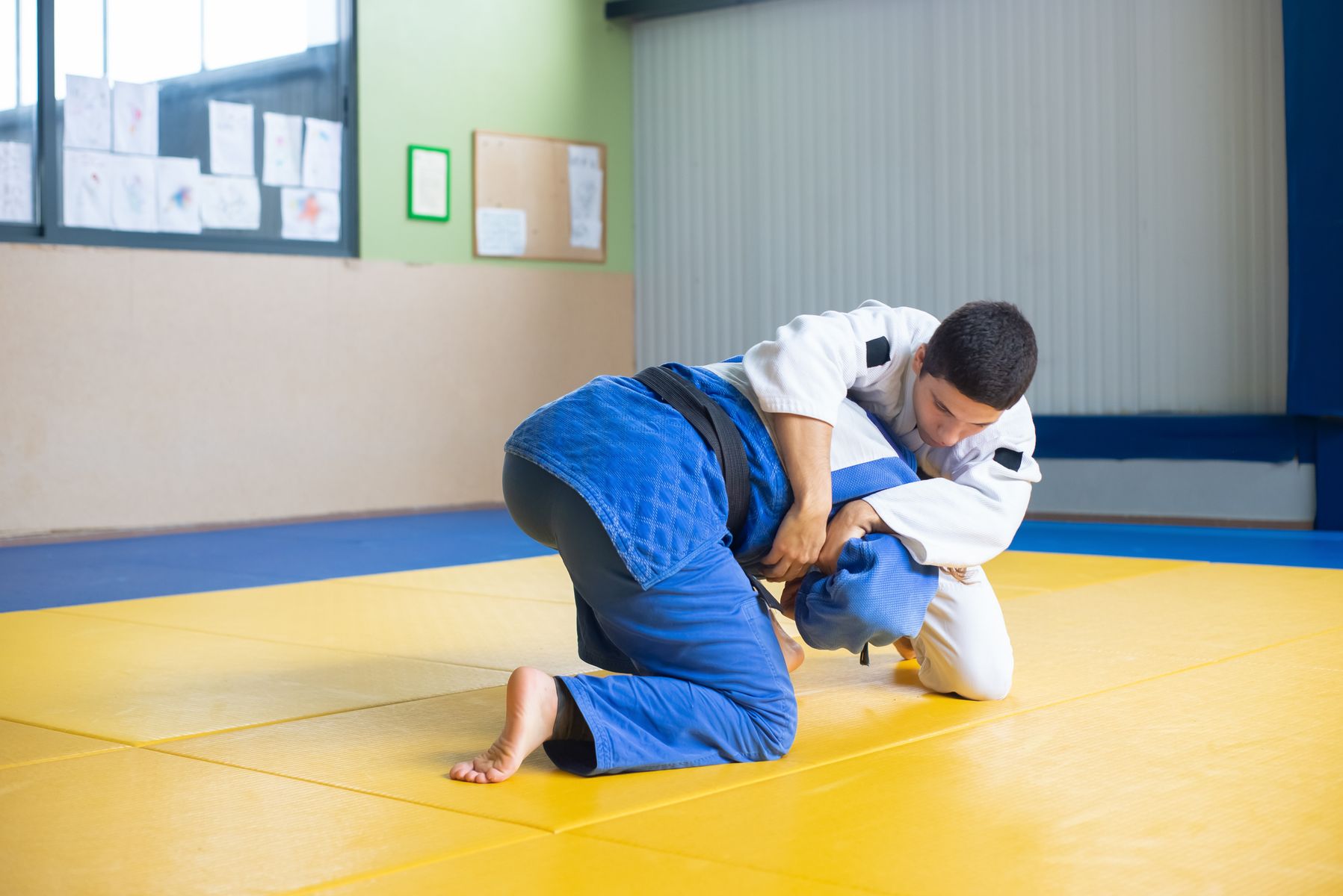 Two fighters grappling on the mat during a training session