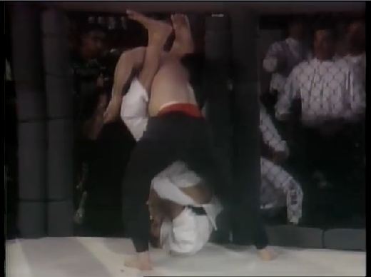 Royce Gracie applying his famous upside-down armbar on Jason DeLucia at UFC 2